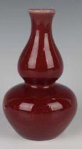 A Chinese sang-de-boeuf glazed porcelain bottle vase, late Qing dynasty, of double gourd form,