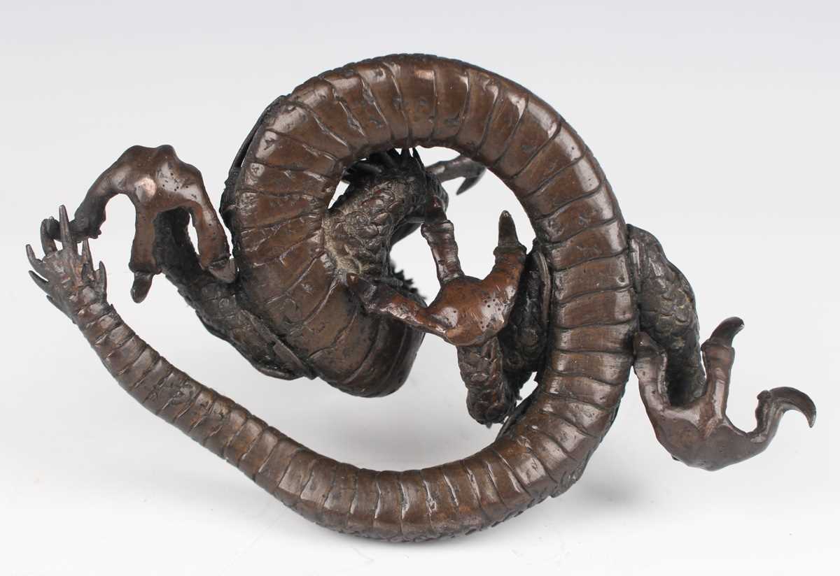 A Japanese cast bronze figure of a dragon, 20th century, modelled in a coiled pose holding a - Image 7 of 9