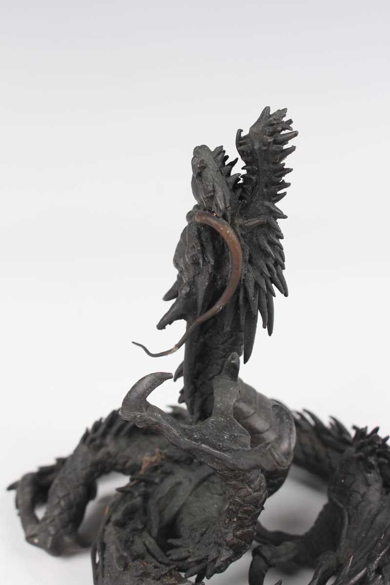 A Japanese cast bronze figure of a dragon, 20th century, modelled in a coiled pose holding a - Image 4 of 9