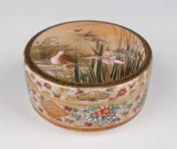 A Japanese Satsuma earthenware circular box and cover by Kusube, Meiji period, the top painted and