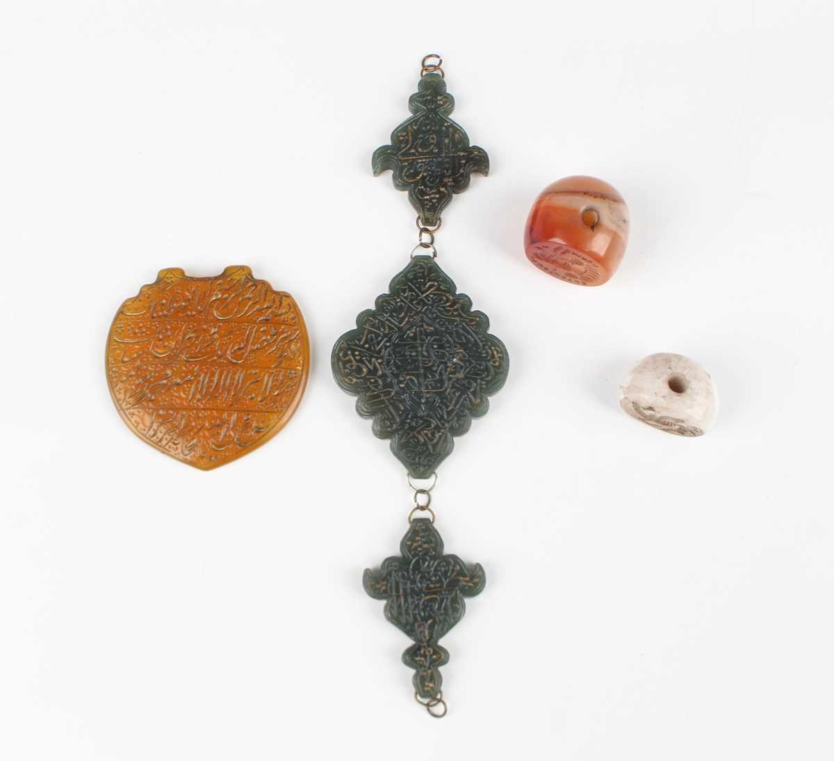 An Islamic dark green jade three-section arm ornament, each piece incised with script, total width