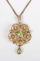 An Edwardian gold, peridot and seed pearl pendant in a cinquefoil shaped design, claw set with the