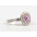 A white gold, pink sapphire and diamond oval cluster ring, claw set with the oval cut pink