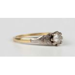 A gold and diamond single stone ring, claw set with a circular cut diamond between foliate