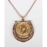 A 9ct gold pendant designed as a horseshoe, mounted with a George V half-sovereign 1912, length 3.