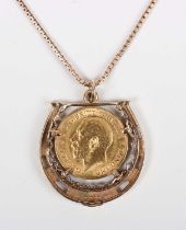 A 9ct gold pendant designed as a horseshoe, mounted with a George V half-sovereign 1912, length 3.