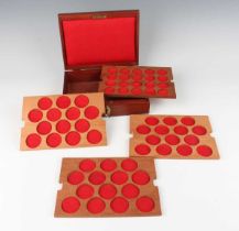 A 20th century mahogany coin collector's box, the four fitted trays with various diameter coin