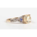 A 14ct gold ring, mounted with a central cabochon pale yellow opal between diamond and pale blue gem