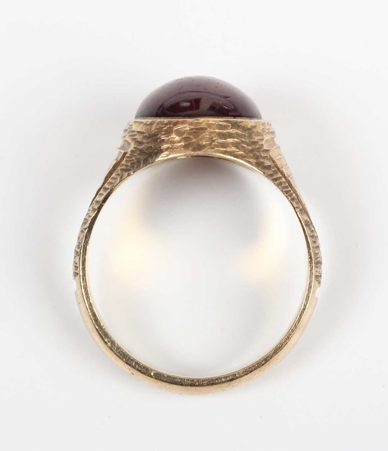 A 9ct gold and carbuncle garnet ring, mounted with an oval carbuncle garnet between textured - Image 4 of 5