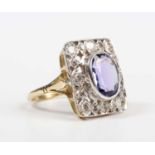 A gold, tanzanite and diamond panel shaped ring, collet set with the oval cut tanzanite within a