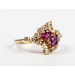 An 18ct gold, ruby and diamond ring, claw set with two pear shaped rubies, otherwise set with