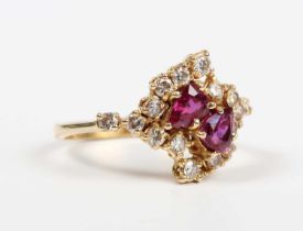 An 18ct gold, ruby and diamond ring, claw set with two pear shaped rubies, otherwise set with