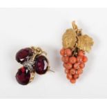 A gold, garnet and diamond pendant brooch in a trefoil shaped design, with a central rose cut