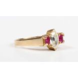 A gold, diamond and ruby ring, claw set with the marquise shaped diamond between two square cut