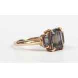 A 9ct gold ring, mounted with a cut cornered rectangular step cut mystic topaz between two smaller