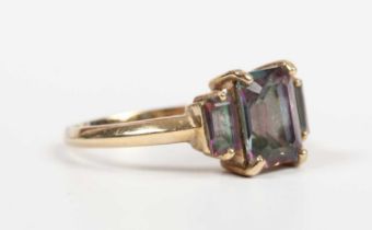 A 9ct gold ring, mounted with a cut cornered rectangular step cut mystic topaz between two smaller