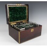 A Victorian rosewood and brass bound travelling vanity box, the compartmentalized interior fitted