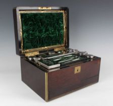 A Victorian rosewood and brass bound travelling vanity box, the compartmentalized interior fitted