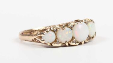 A gold, opal and diamond ring, mounted with a row of five graduated circular opals with four pairs