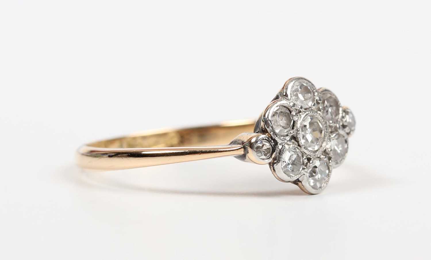 A gold, platinum and diamond nine stone cluster ring in a lozenge shaped design, mounted with