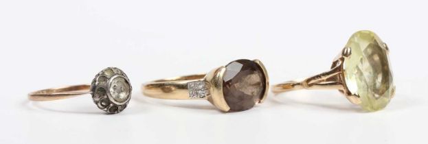 A gold, smoky quartz and diamond ring, mounted with an oval cut smoky quartz between diamond four