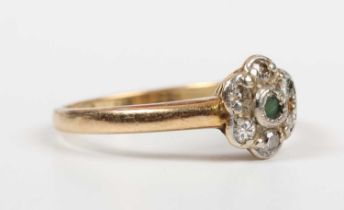 A gold and platinum, emerald and diamond cluster ring, mounted with the circular cut emerald