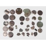 A collection of various metal detector-found coins, including Roman and hammered (most in ground-