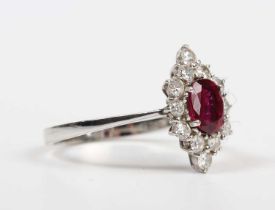 A ruby and diamond cluster ring, claw set with the oval cut ruby within a marquise shaped surround