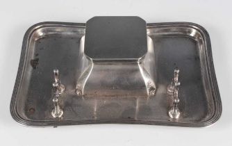A George VI silver inkstand, the square baluster well with hinged lid, the shaped rectangular