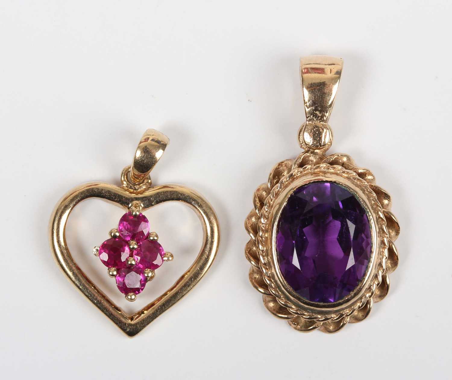 A 9ct gold and ruby pendant in a heart shaped design, mounted with four circular cut rubies, - Image 2 of 3