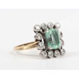 A gold and platinum, emerald and diamond cluster ring, claw set with the cut cornered rectangular