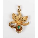 A gold and emerald pendant designed as an orchid flowerhead, claw set with a rectangular step cut