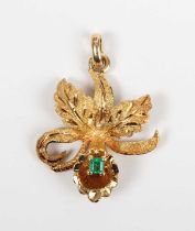 A gold and emerald pendant designed as an orchid flowerhead, claw set with a rectangular step cut