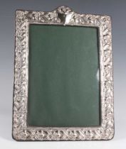 An Elizabeth II silver mounted rectangular photograph frame with arched top, embossed with