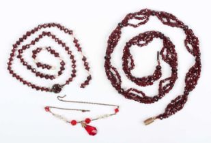 A multiple strand necklace of faceted garnet beads, with larger garnet beads mounted at intervals,