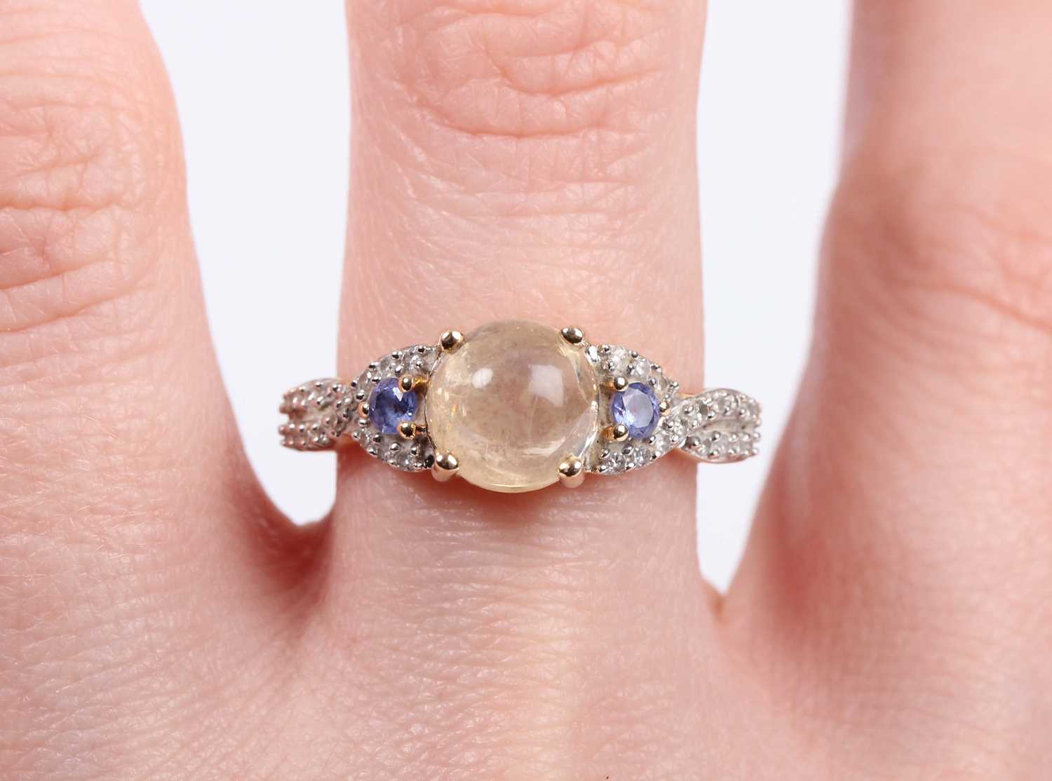 A 14ct gold ring, mounted with a central cabochon pale yellow opal between diamond and pale blue gem - Image 5 of 5