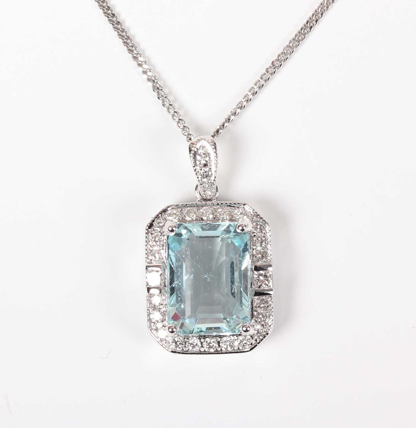 A white gold, aquamarine and diamond cluster pendant, claw set with the cut cornered rectangular