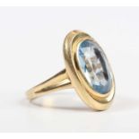 A gold ring, collet set with a large oval cut synthetic blue spinel, detailed ‘750’, weight 6.3g,