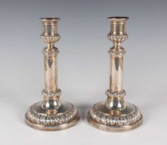 A pair of George IV silver telescopic candlesticks, each with half-reeded urn shaped sconce above