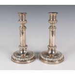 A pair of George IV silver telescopic candlesticks, each with half-reeded urn shaped sconce above