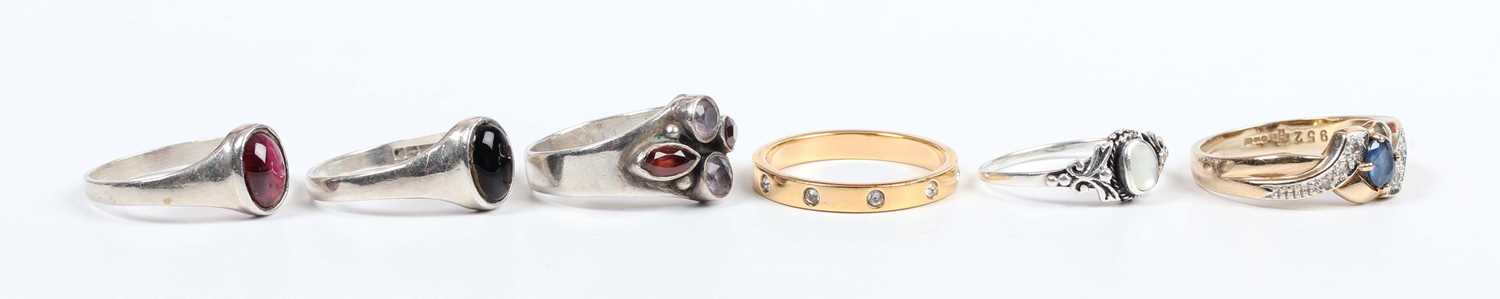 A 9ct gold, sapphire and diamond ring, claw set with the oval cut sapphire between diamond three