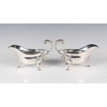 A pair of late Victorian silver sauceboats, each with shaped rim and foliate capped scroll handle,