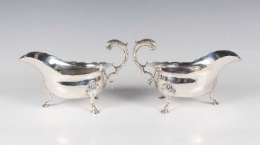A pair of late Victorian silver sauceboats, each with shaped rim and foliate capped scroll handle,