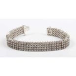 A white gold and diamond bracelet, mounted with four rows of circular cut diamonds, on a snap clasp,