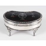 A George V silver and tortoiseshell kidney shaped trinket box with piqué inlaid decoration, on