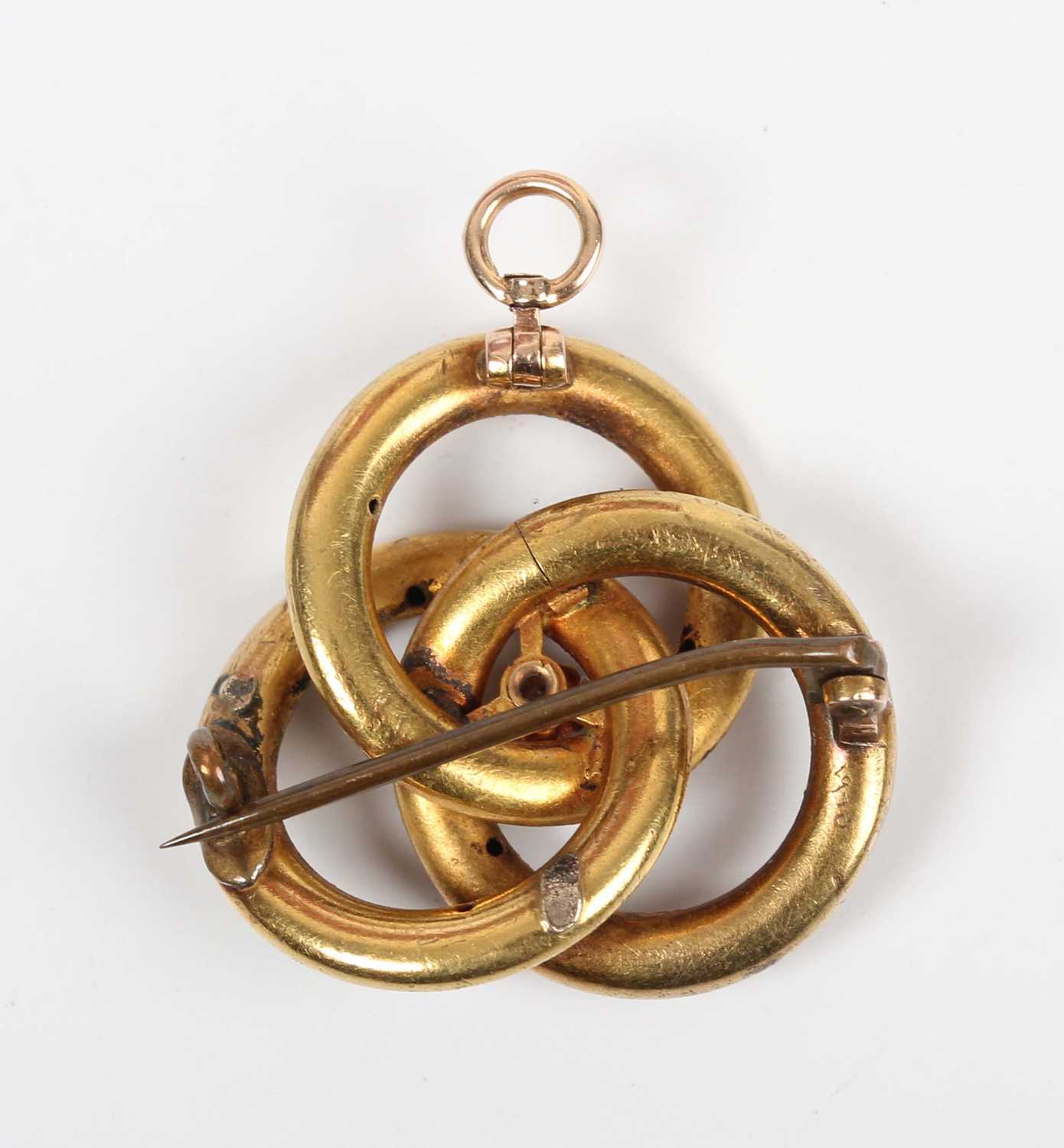 A gold, diamond and enamelled pendant brooch in an entwined trefoil design, claw set with a - Image 2 of 3