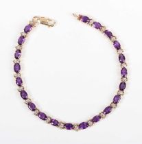 A gold and amethyst bracelet, claw set with a row of oval cut amethysts, detailed ‘10K’, on a sprung