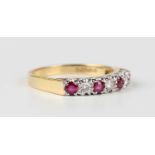 An 18ct gold, ruby and diamond ring, mounted with four circular cut rubies alternating with three