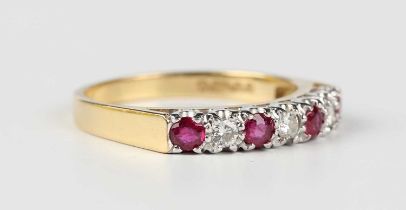 An 18ct gold, ruby and diamond ring, mounted with four circular cut rubies alternating with three