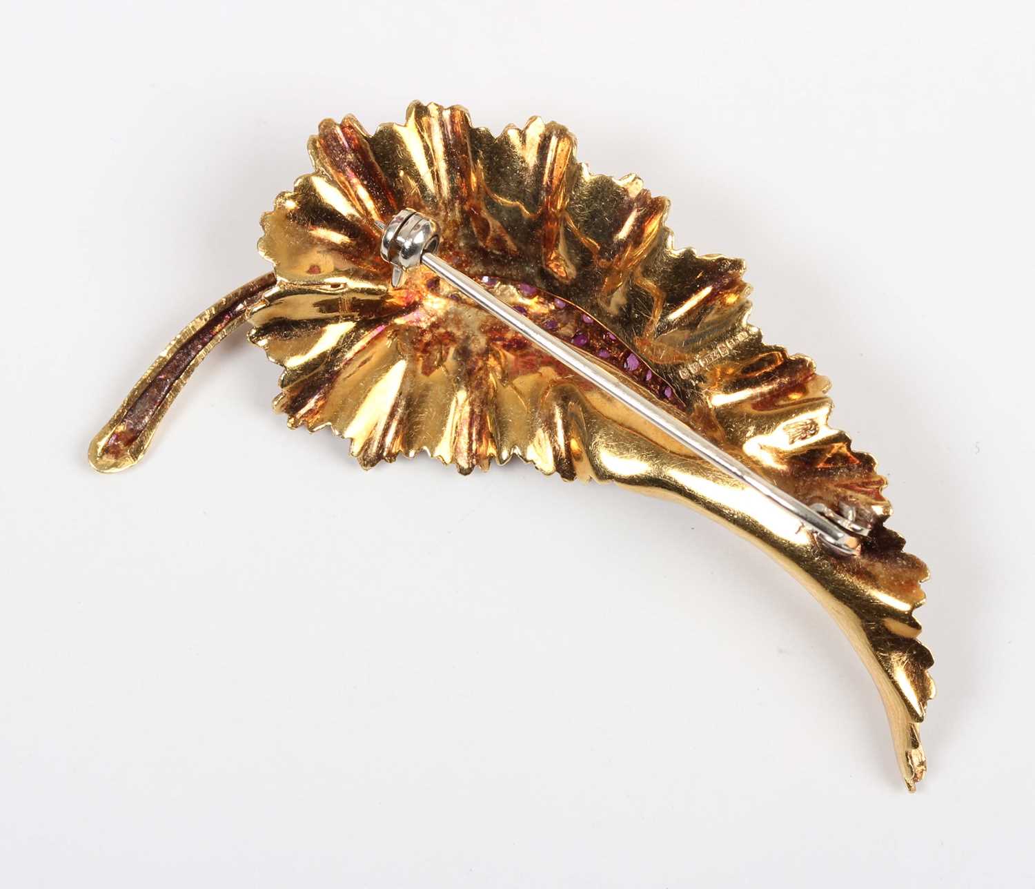 An 18ct gold and ruby brooch, designed as a leaf with a textured finish, mounted with circular cut - Image 2 of 2